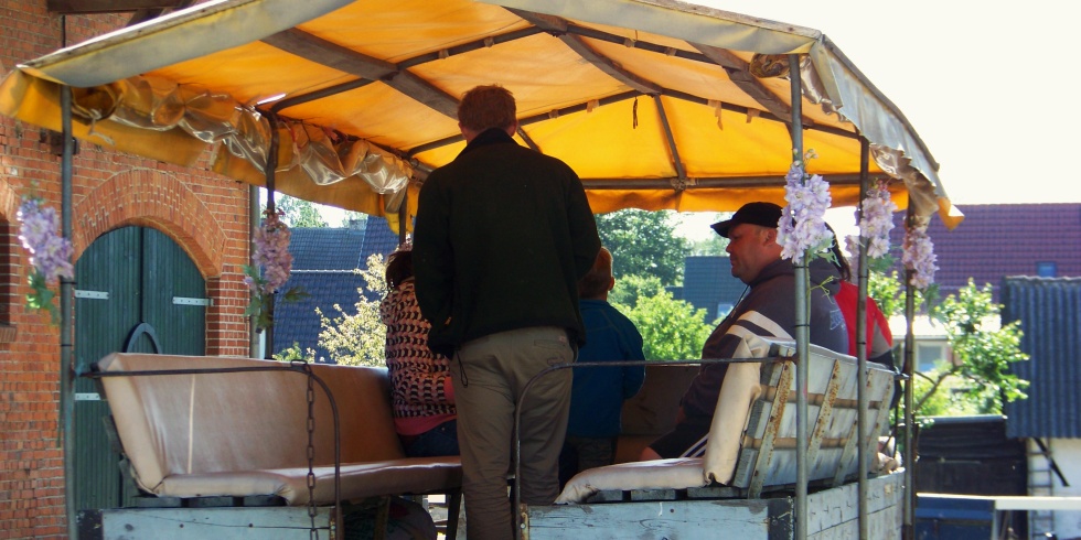 Menschen auf einem Krmeserwage warten auf ihre Bauernhofsafari
